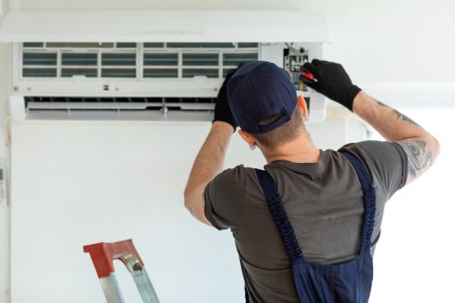 Technician repairing air conditioner AC Repair in Friendswood, TX, and Surrounding Areas